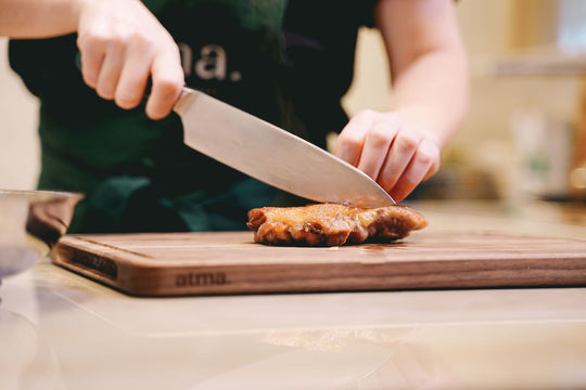 Couteau de chef Atma sur planche à découper en bois