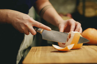 couteau de chef forgé découpe un pomelo